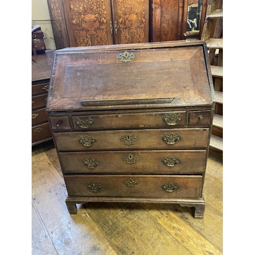 713 - An 18th century oak and mahogany crossbanded bureau, the fall front revealling a well, drawers and p... 