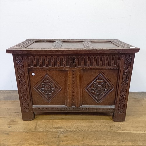 696 - An 18th century oak coffer, of small proportions, with carved decoration, on stile legs, 84 cm wide