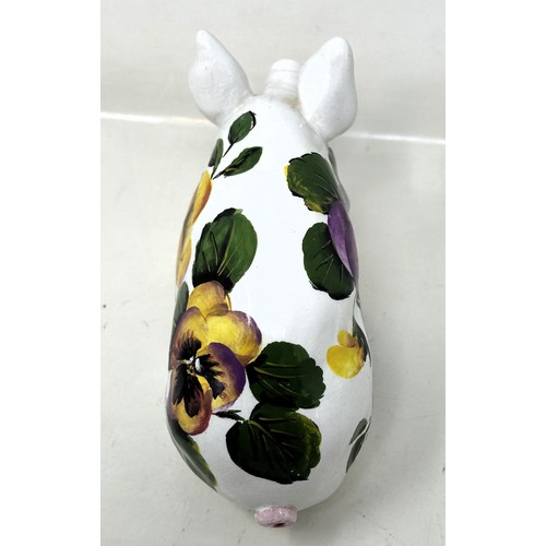 388 - An Exon Wemyss pottery pig, decorated flowers, signed B Adams and dated '87, 18 cm wide