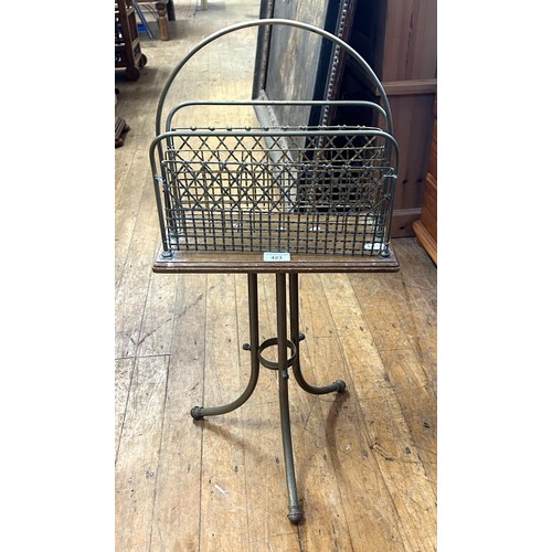 423 - An early 20th century brass and oak magazine rack, 80 cm high