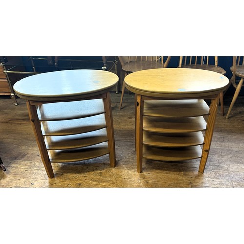 427 - A pair of 20th century teak oval side tables, with revolving tops, 62 cm wide (2)