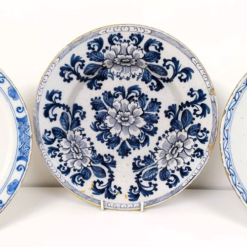 510 - A blue and white Delft plate, decorated flowers, 23 cm diameter, and two others (3)