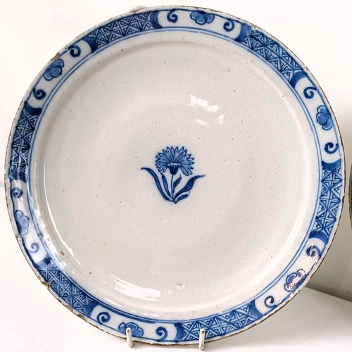 510 - A blue and white Delft plate, decorated flowers, 23 cm diameter, and two others (3)