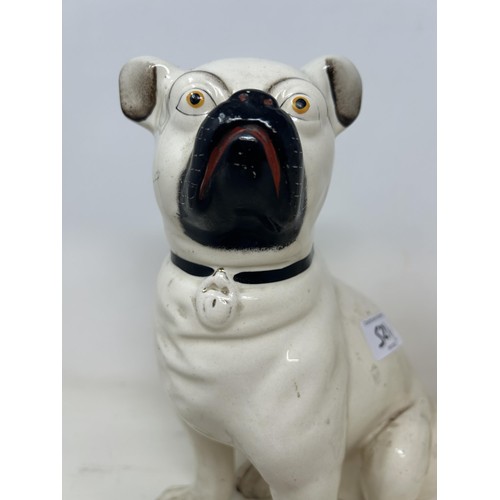 521 - A pair of pottery pugs, 28 cm high (2)