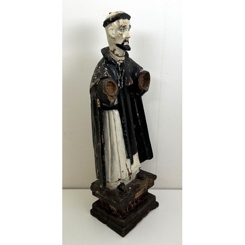 536 - A carved and painted figure of a saint, lacking arms, on a rectangular base, 60 cm high