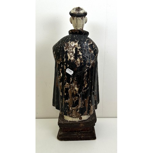 536 - A carved and painted figure of a saint, lacking arms, on a rectangular base, 60 cm high