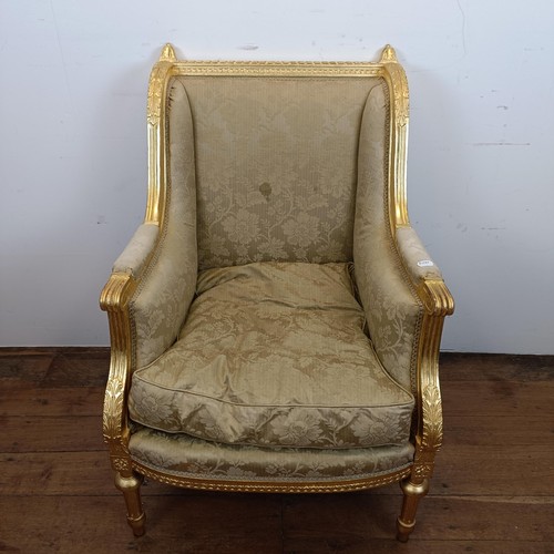 663 - A French gilt armchair, with a padded back, arms and seat, on turned and reeded legs