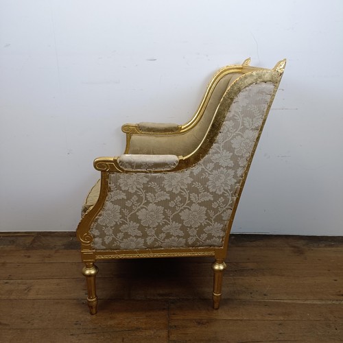 663 - A French gilt armchair, with a padded back, arms and seat, on turned and reeded legs