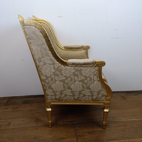 663 - A French gilt armchair, with a padded back, arms and seat, on turned and reeded legs