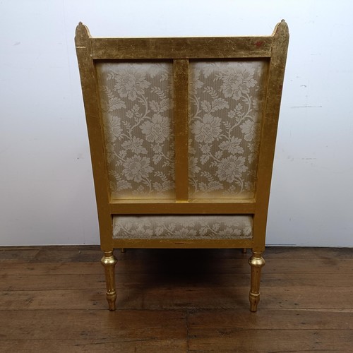 663 - A French gilt armchair, with a padded back, arms and seat, on turned and reeded legs