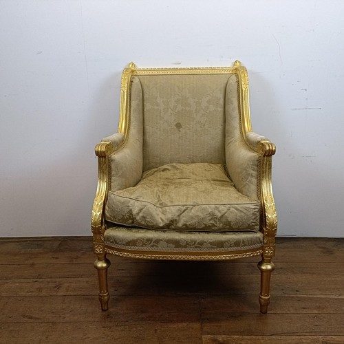 663 - A French gilt armchair, with a padded back, arms and seat, on turned and reeded legs