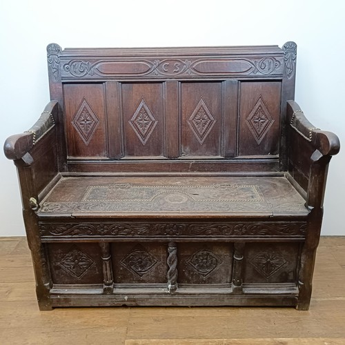 666 - A 17th century style carved oak settle, with a painted leather panel to the seat and arms, 130 cm wi... 