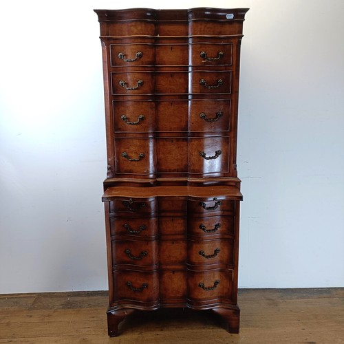 715 - An 18th century style walnut tallboy, of shaped form, the top having four graduated drawers, on a ba... 