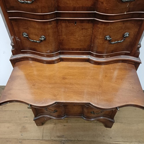 715 - An 18th century style walnut tallboy, of shaped form, the top having four graduated drawers, on a ba... 