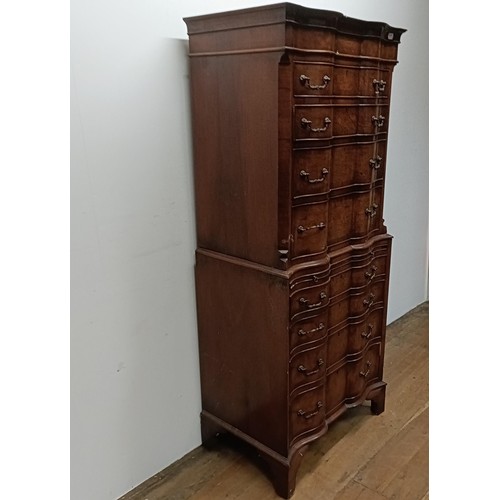 715 - An 18th century style walnut tallboy, of shaped form, the top having four graduated drawers, on a ba... 