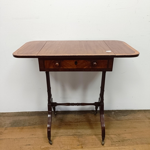 718 - A 19th century mahogany work table, on twin end supports united by a stretcher, 46 cm wide