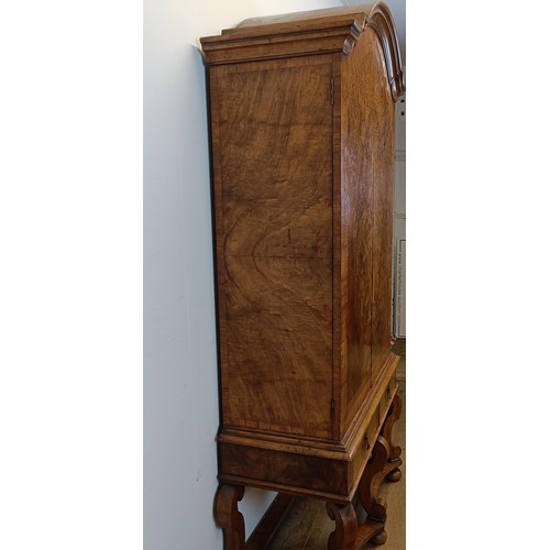 723 - An 18th century style walnut cabinet on stand, the top with two doors revealling a fitted interior w... 