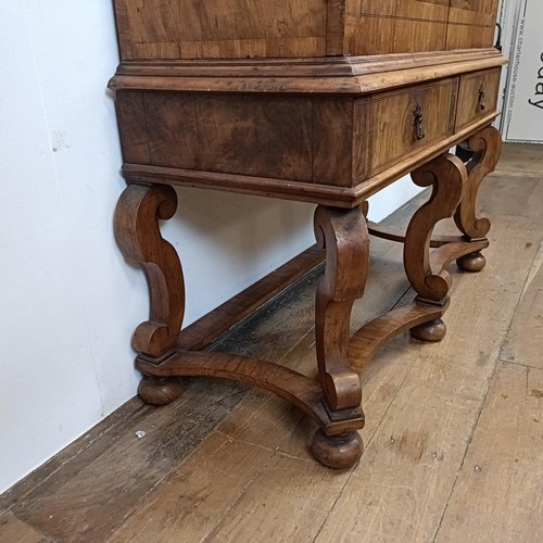 723 - An 18th century style walnut cabinet on stand, the top with two doors revealling a fitted interior w... 