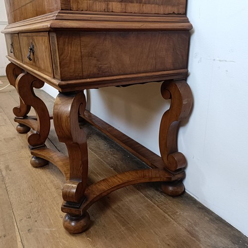 723 - An 18th century style walnut cabinet on stand, the top with two doors revealling a fitted interior w... 