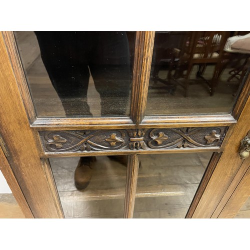 726 - An oak bookcase, with three glazed doors, 154 cm wide