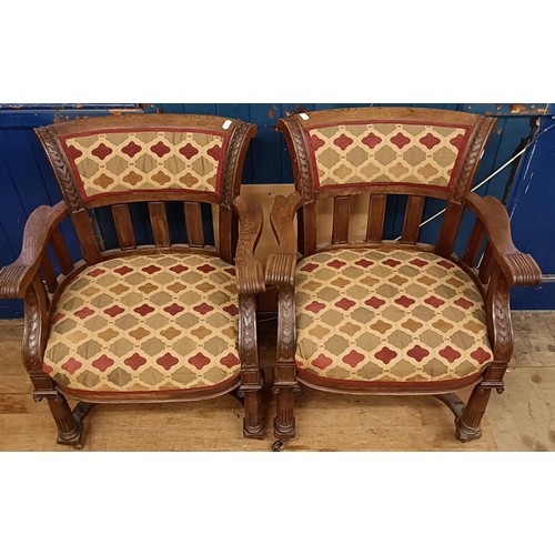 755 - A pair of late Victorian carved oak armchairs, with padded backs and seats, on ionic column legs to ... 