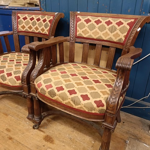 755 - A pair of late Victorian carved oak armchairs, with padded backs and seats, on ionic column legs to ... 