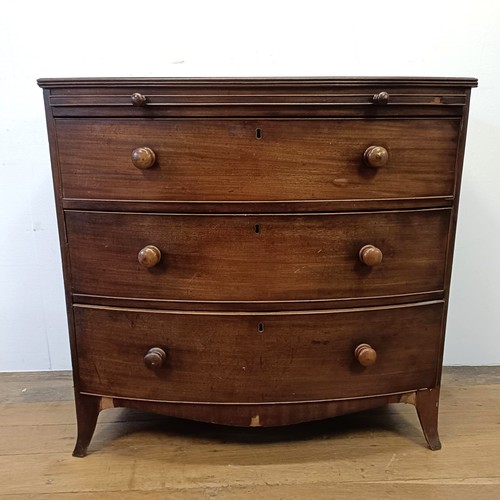 667 - A mahogany bow front chest, having a brushing slide above three drawers, 93 cm wide