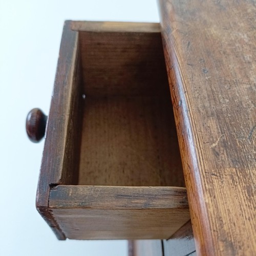 704 - A miniature table top pine chest, having two short and two long drawers, on turned feet, 30 cm high ... 