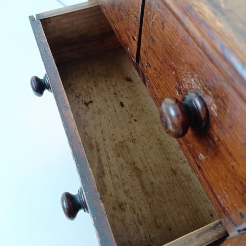 704 - A miniature table top pine chest, having two short and two long drawers, on turned feet, 30 cm high ... 