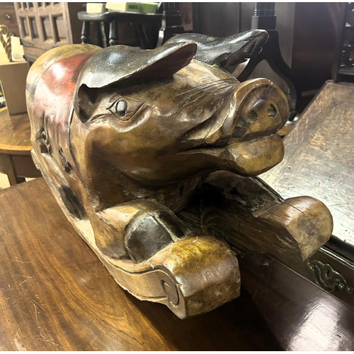 631 - A 20th century rocking pig and a wooden door stop