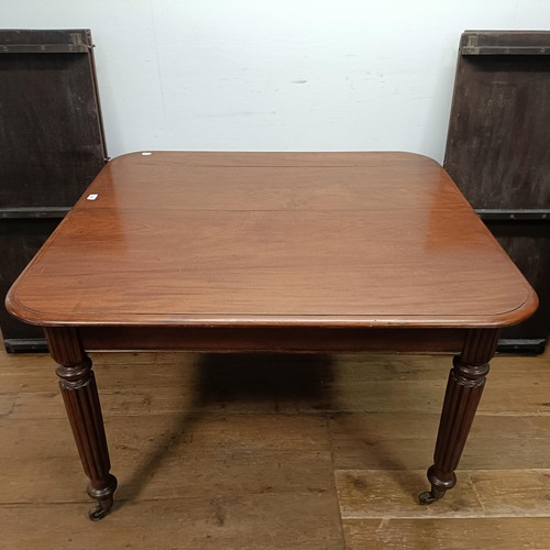 650 - A 19th century mahogany extending dining table, on turned reeded legs to castors, with four extra le... 