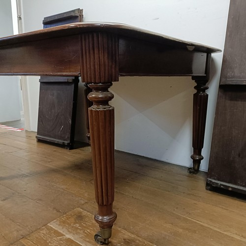 650 - A 19th century mahogany extending dining table, on turned reeded legs to castors, with four extra le... 