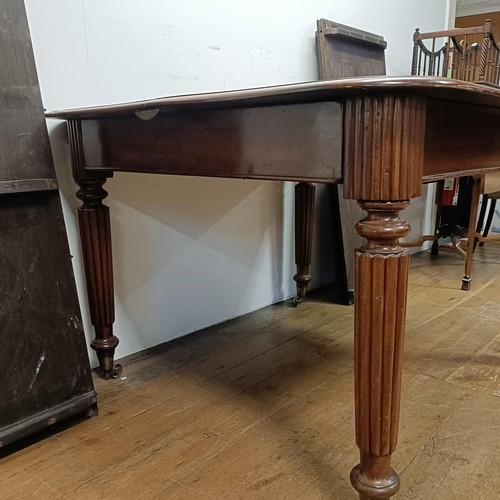 650 - A 19th century mahogany extending dining table, on turned reeded legs to castors, with four extra le... 