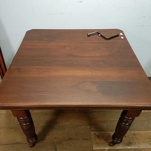 648 - A mahogany extending dining table, with an extra leaf, on turned tapering legs and castors, the top ... 