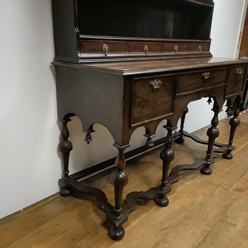 728 - An 18th century style dresser, veneered in walnut, having a three tier plate rack, on a base with th... 