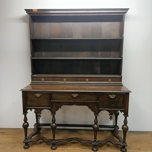 728 - An 18th century style dresser, veneered in walnut, having a three tier plate rack, on a base with th... 