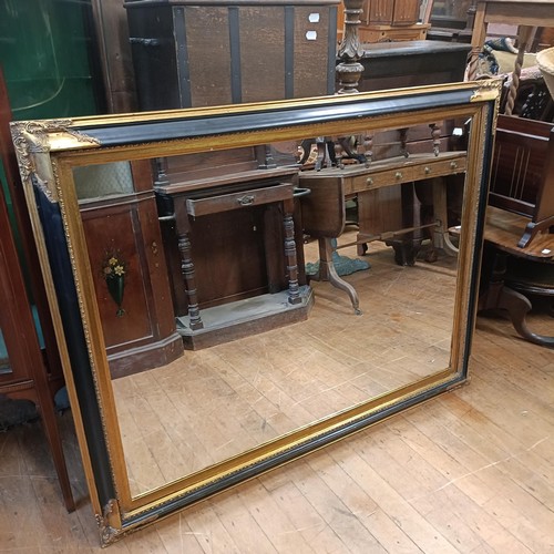 770 - A wall mirror, with a gilt and painted black frame, 110 x 143 cm, a pine wall mirror, 105 x 140 cm, ... 