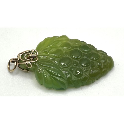 54 - A carved green stone pendant, decorated grapes, with a yellow metal mount