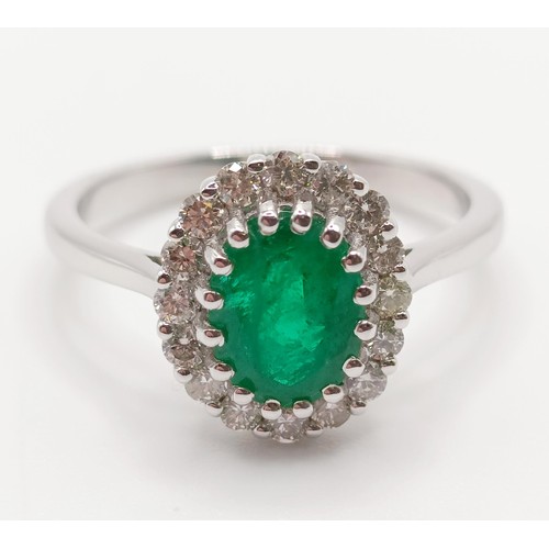 63 - An 18ct white gold, oval emerald and diamond cluster ring, emerald 1.31ct, RBC diamonds 0.37ct