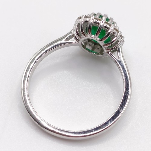 63 - An 18ct white gold, oval emerald and diamond cluster ring, emerald 1.31ct, RBC diamonds 0.37ct