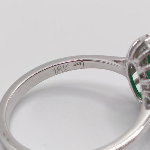 63 - An 18ct white gold, oval emerald and diamond cluster ring, emerald 1.31ct, RBC diamonds 0.37ct