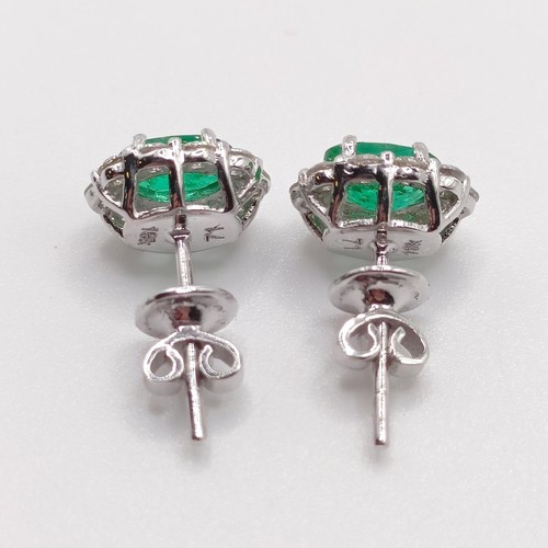 83 - A pair of 18ct white gold, oval emerald and RBC diamond cluster studs, boxed, emeralds 0.58ct, RBC d... 