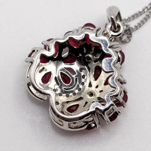 90 - A foliate silver pendant, set with pear-shaped rubies and R/C white sapphires on a silver chain, rub... 