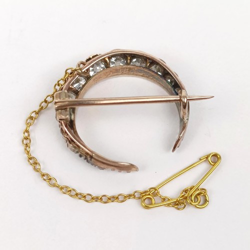 98 - An early 20th century diamond crescent brooch, all in 2.7 g