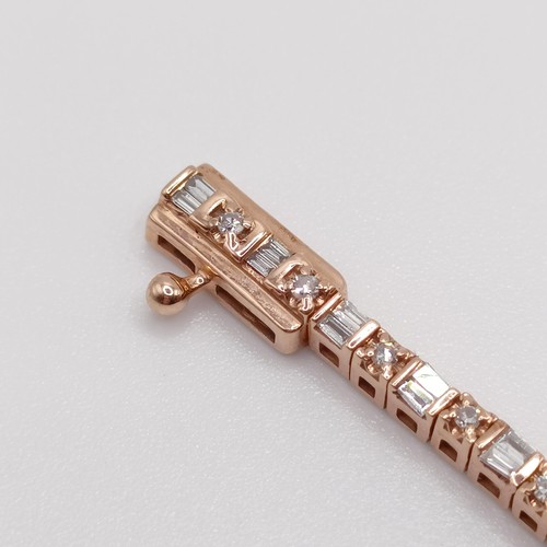 107 - An unusual 10ct rose gold bracelet, set with baguette and RBC diamonds, with an open box clasp and s... 