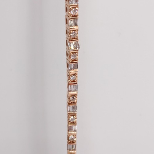 107 - An unusual 10ct rose gold bracelet, set with baguette and RBC diamonds, with an open box clasp and s... 