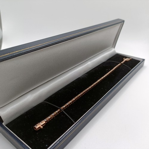 107 - An unusual 10ct rose gold bracelet, set with baguette and RBC diamonds, with an open box clasp and s... 