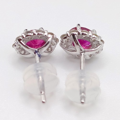 108 - A pair of 18ct white gold oval ruby and diamond cluster studs, boxed, rubies 0.60ct, R/C diamonds 0.... 