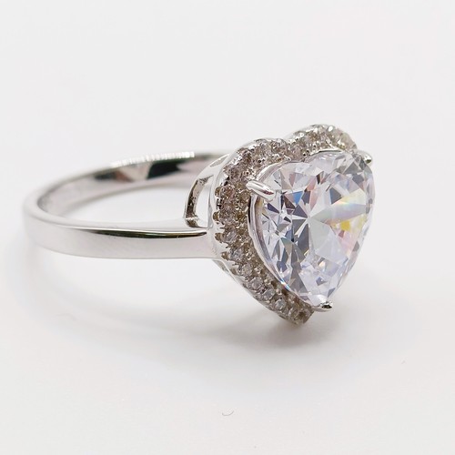 128 - A silver ring, with large heart shaped white CZ at the centre within a surround of smaller round CZs