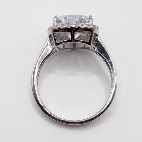 128 - A silver ring, with large heart shaped white CZ at the centre within a surround of smaller round CZs